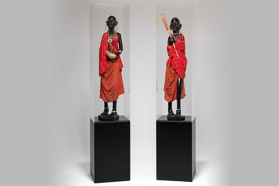 pair of statuettes on pedestals in side a display box